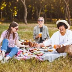 group-laughing-girls-happily-spending-time-beautiful-picnic-with-little-dog-park_574295-856