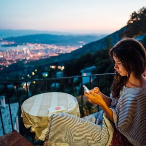 woman-sits-balcony-background-night-city_1153-3810